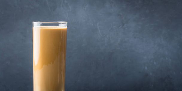 Long glass with coffee and cream on dark background. Banner - Photo, image