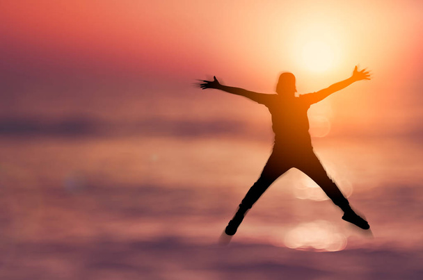 Wohlfühl- und Freiheitskonzept. Kopie eines glücklichen Mannes, der am Strand des tropischen Sonnenuntergangs springt. - Foto, Bild