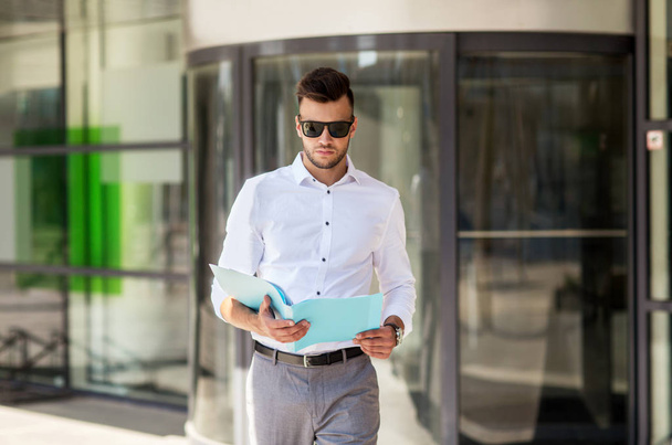 young man with business file on city street - 写真・画像