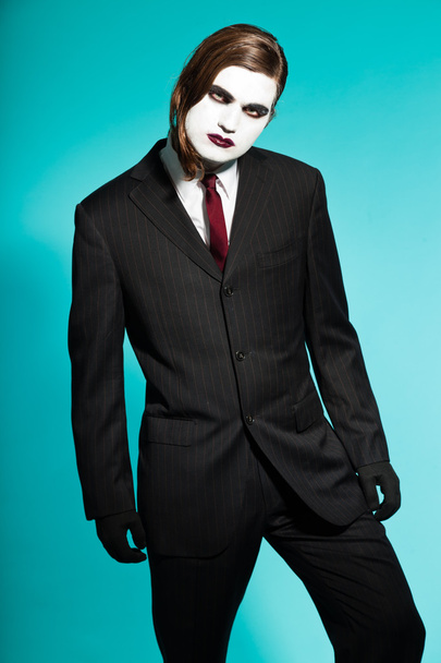 Gothic vampire looking business man wearing black striped suit and dark red tie. - Fotó, kép