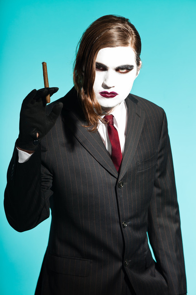 Homme d'affaires gothique à la recherche de vampire portant un costume rayé noir et une cravate rouge foncé
. - Photo, image