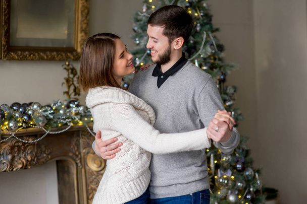 Couple of lovers dancing near the Christmas tree - Zdjęcie, obraz