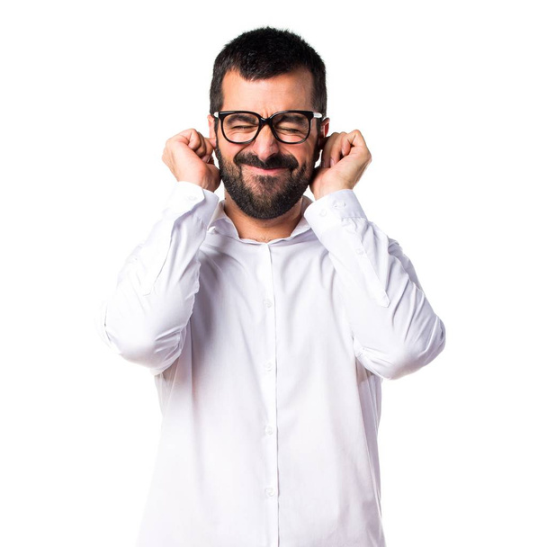 Handsome man with glasses covering his ears - Foto, immagini