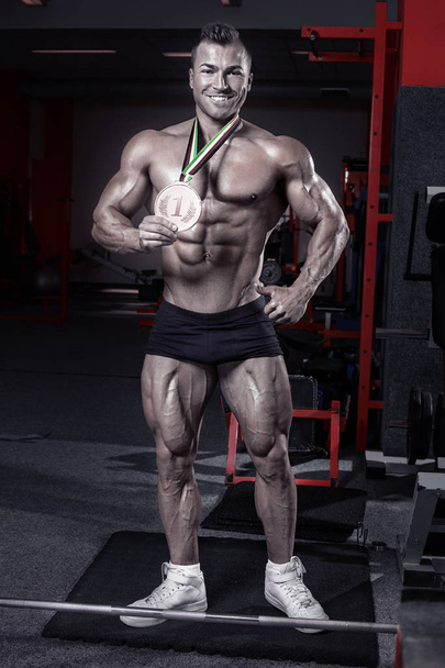 Muscular bodybuilder guy with trophy - Photo, Image