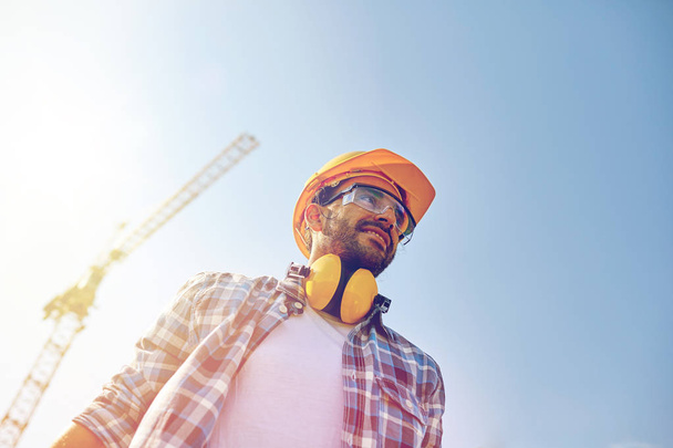 smiling builder with hardhat and headphones - Φωτογραφία, εικόνα
