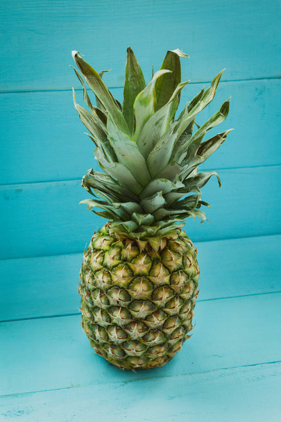 Pineapple on blue wooden table - Foto, Imagen