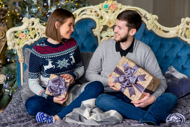 Couple of lovers sitting on the sofa. Christmas time - Photo, image
