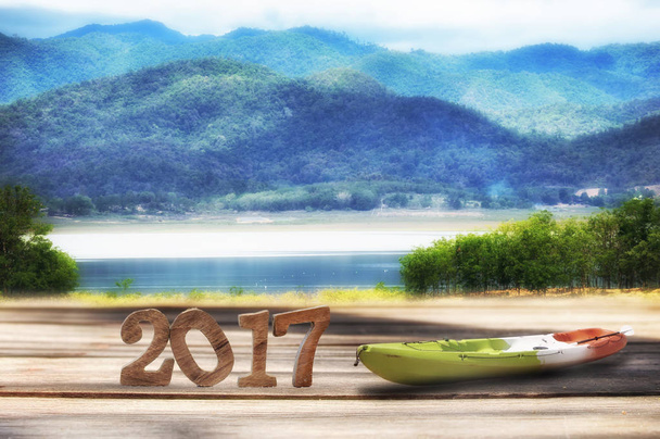 Feliz año nuevo 2017 sobre tabla de madera y paisaje de montaña vista de fondo
 - Foto, Imagen