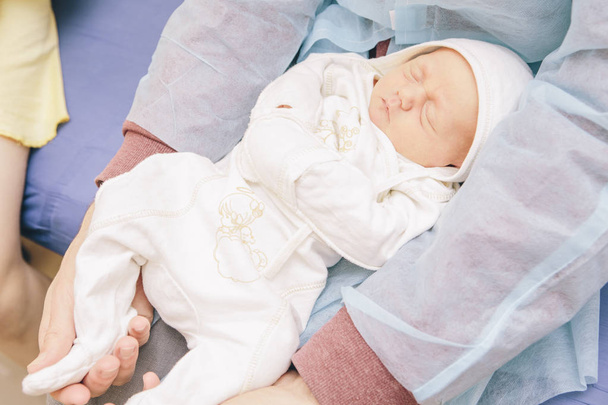 Little infant newborn child in maternity hospital on his fathers - Foto, afbeelding