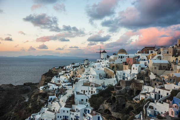 White city on a slope of a hill at sunset, Oia, Santorini, Greec - Fotó, kép