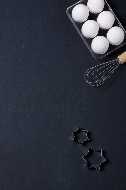 Baking background with eggs, whisk and star cookie cutter - Photo, Image