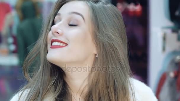 Щаслива дівчина намагається і позує в шубі в магазині. Повільно
 - Кадри, відео