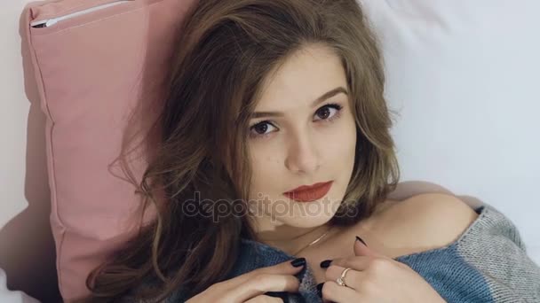 Smart girl relaxing, lying and posing on the bed. Slowly - Filmati, video