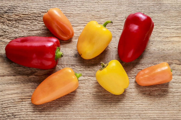Colorful peppers on wooden background - Foto, afbeelding