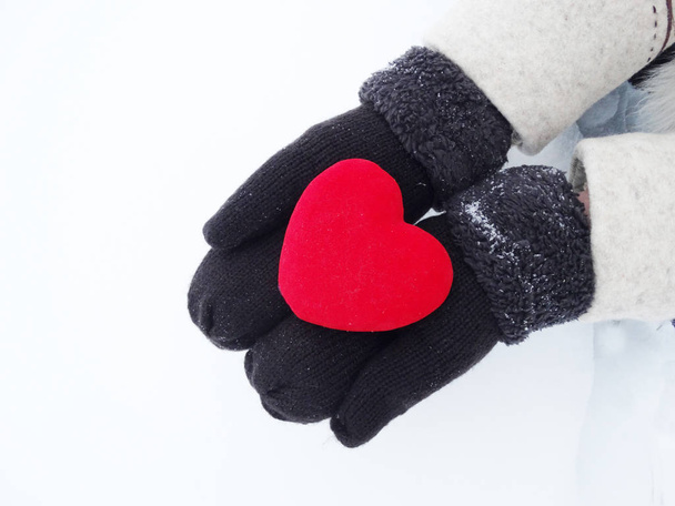 woman hands in mittens with red heart on snow - Foto, Imagem