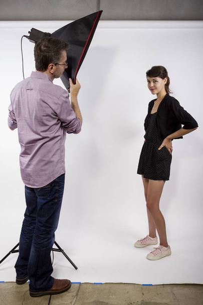 Photographer Demonstrating Studio Photography with a Model - Foto, imagen