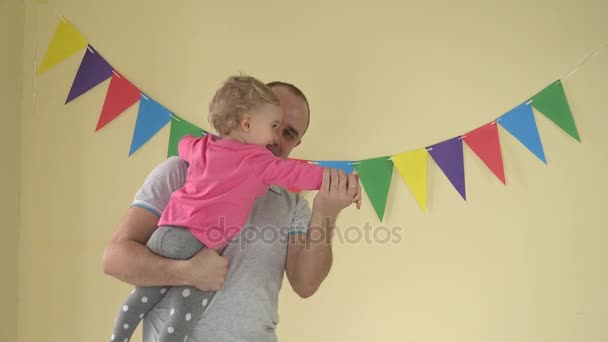 junger glücklicher Vater hält kleine Tochter auf dem Arm und sie tanzen zu Hause - Filmmaterial, Video