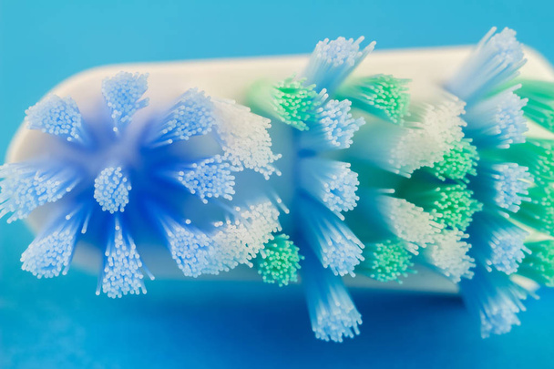 Макрофото зубной щетки на голубом фоне
. - Фото, изображение