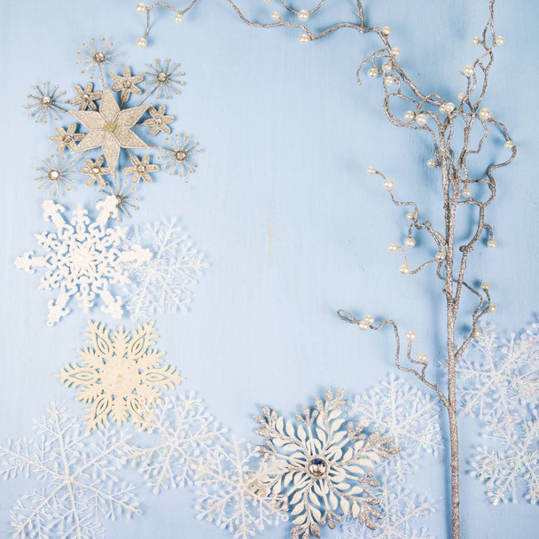 Silver decorative snowflakes and branch on a blue wooden backgro - Foto, immagini