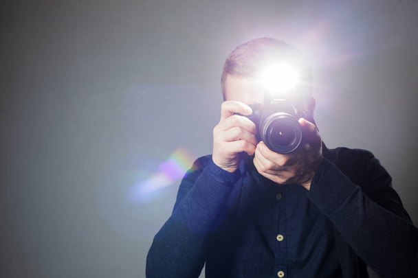 Photographe prend une photo en studio à l'aide d'un flash
 - Photo, image