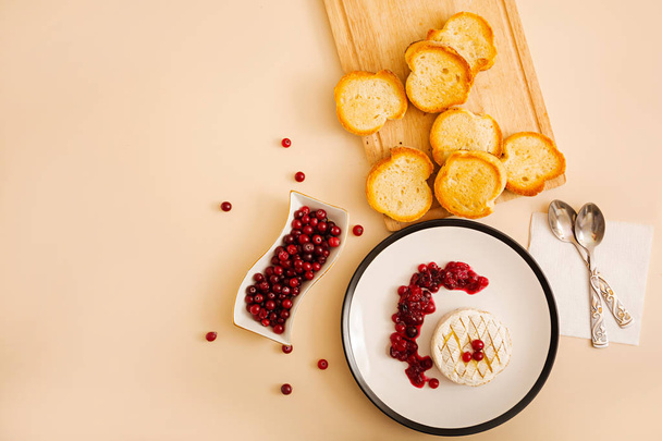 Baked Camembert with cranberries and toasted bread. Top view - Photo, Image