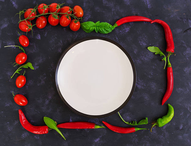 Fresh ripe cherry tomatoes and pepper on a dark background. Top view - 写真・画像