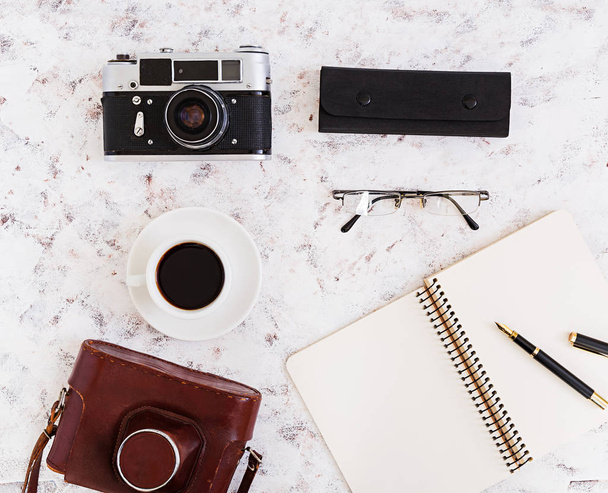 Flat lay, top view office table desk. Desk workspace with retro camera, diary, pen, glasses, case, cup of coffee on white background. - Fotoğraf, Görsel
