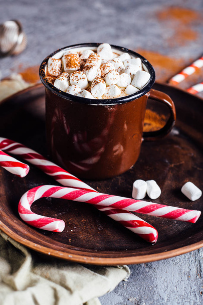 Vintage mug of hot chocolate with cinnamon sticks over dark background - Zdjęcie, obraz