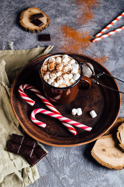 Vintage mug of hot chocolate with cinnamon sticks over dark background - Fotografie, Obrázek