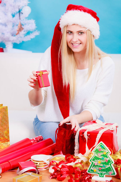 Woman in Santa hat preparing christmas gifts - Foto, Imagem