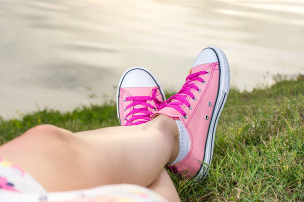 Disfrutando junto al lago. Mujer con zapatillas rosas
 - Foto, imagen