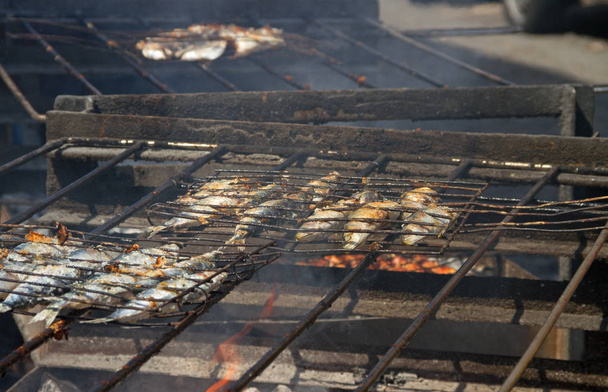 Pescado frito sobre un carbón caliente
. - Foto, imagen