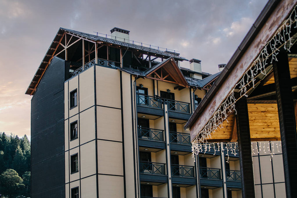 arkhyz, russland - 29. september 2014: wunderschönes arkhyz hotel liegt an einem sonnigen berghang neben skiliften und ausgerüsteten pisten, umgeben von malerischen kaukasusbergen - Foto, Bild