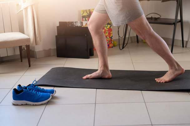 Мужчина делает упражнения тела и тренировки дома
 - Фото, изображение