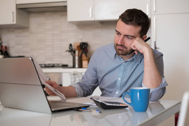 Розчарований чоловік обчислює рахунки та податкові витрати
 - Фото, зображення