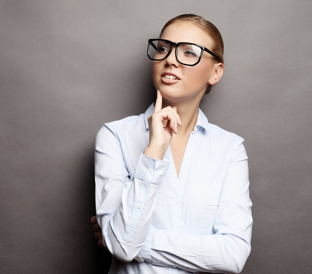 happy smiling young business woman in glasses, over grey  backgr - Фото, изображение