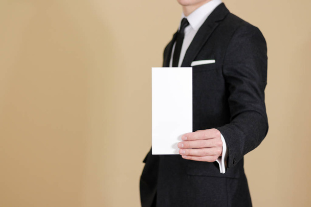 Man showing blank black flyer brochure booklet. Leaflet presenta - Фото, изображение