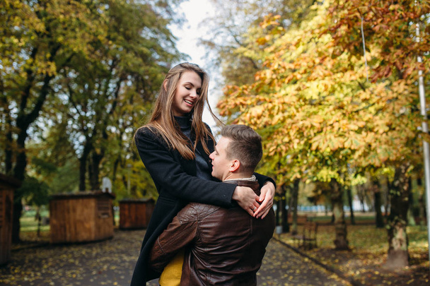 attractive happy couple walking in autumn park - Fotoğraf, Görsel