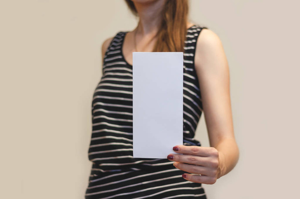 Girl showing blank white flyer brochure booklet. Leaflet present - Foto, Imagem
