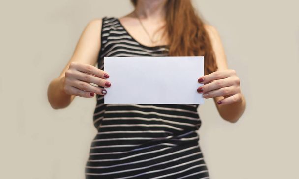 Girl showing blank white flyer brochure booklet. Leaflet present - Zdjęcie, obraz