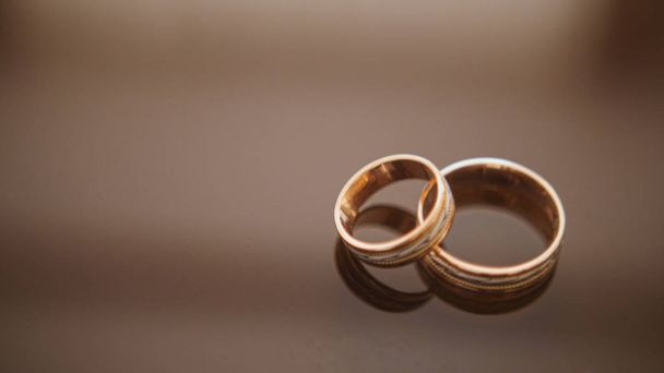 Anéis de casamento dourados na mesa de óculos de espelho - um está no topo do outro
 - Foto, Imagem