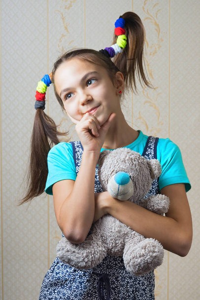 11 year old girl with funny tails hugging a teddy bear - Photo, Image