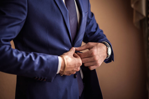 Zakenman draagt een jas. Man's stijl, mannelijke handen close-up, politicus, zakenman, Amerikaanse, Europese, business, mode en kleding concept - Foto, afbeelding