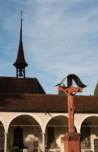 Luzern: Glockenturm und Kruzifix auf dem Friedhof an der Kirche St. Leodegar - Foto, Bild