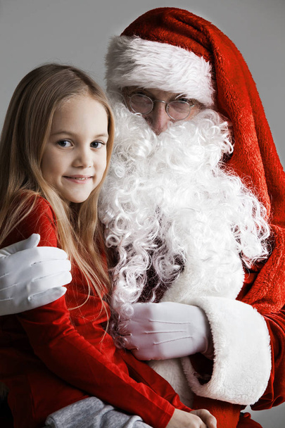 Girl sitting on the lap of Santa Claus - Fotoğraf, Görsel