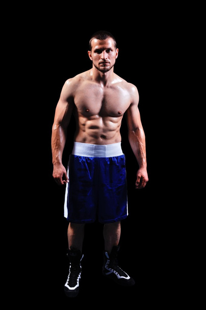Powerful muscular boxer posing on black background - Photo, image