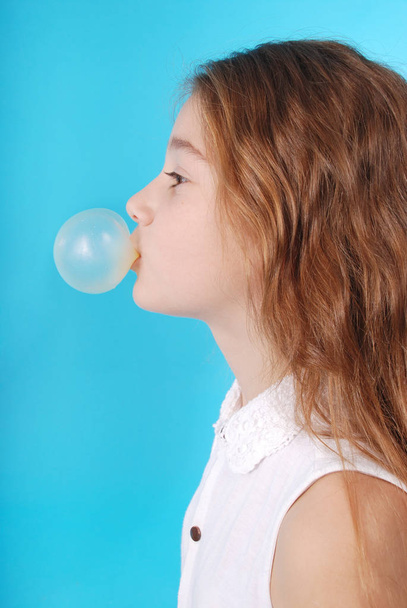 Chica joven haciendo burbuja con goma de mascar
 - Foto, imagen