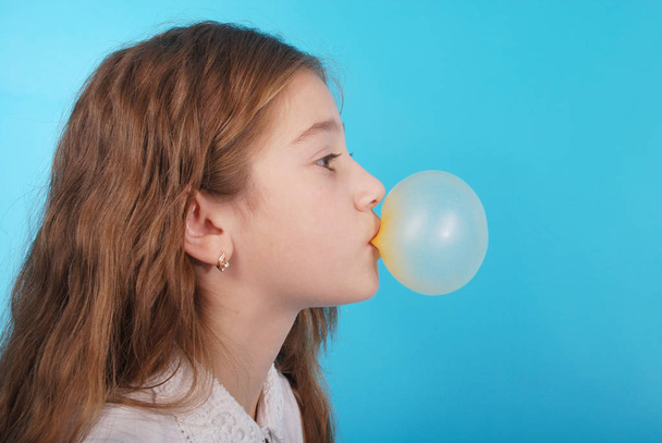 Jong meisje maakt een grote zeepbel met een kauwgom - Foto, afbeelding