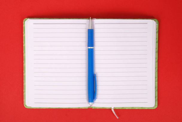 Groene notebook en blauwe pen - Foto, afbeelding