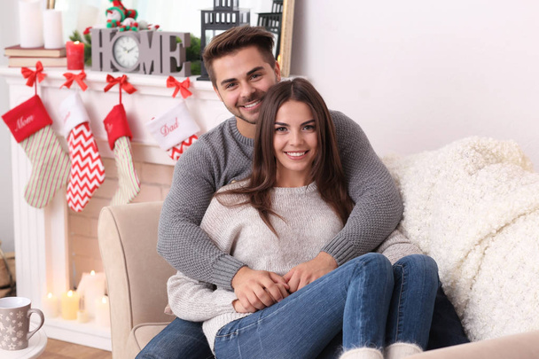 Portrait of young couple in room with Christmas decorations - Foto, Bild